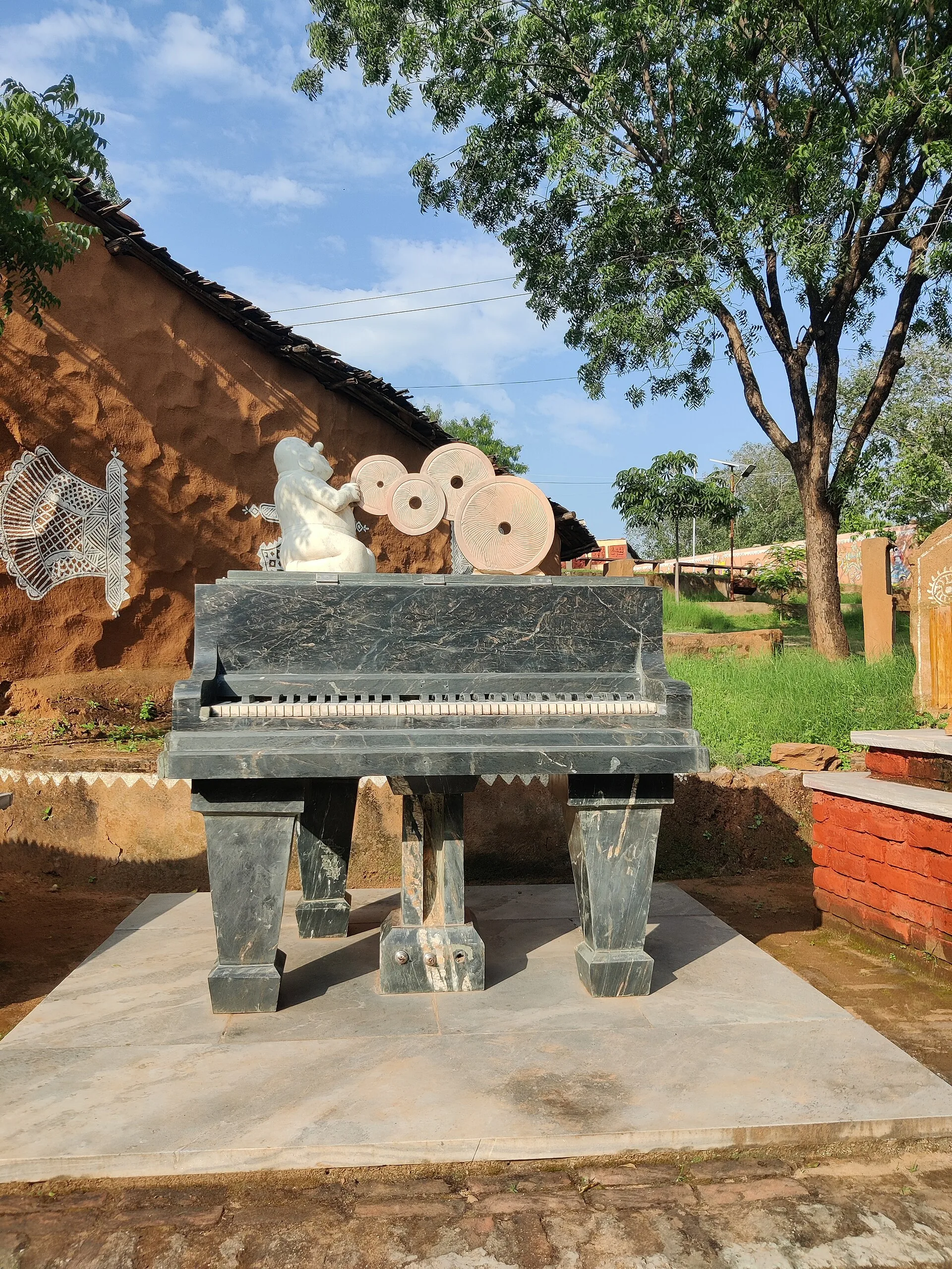 Craft displays and traditional structures at Shilpgram in Udaipur