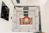 Elara: Sectional sofa and open staircase viewed from above