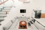Elara: Living room with a sectional sofa and open staircase